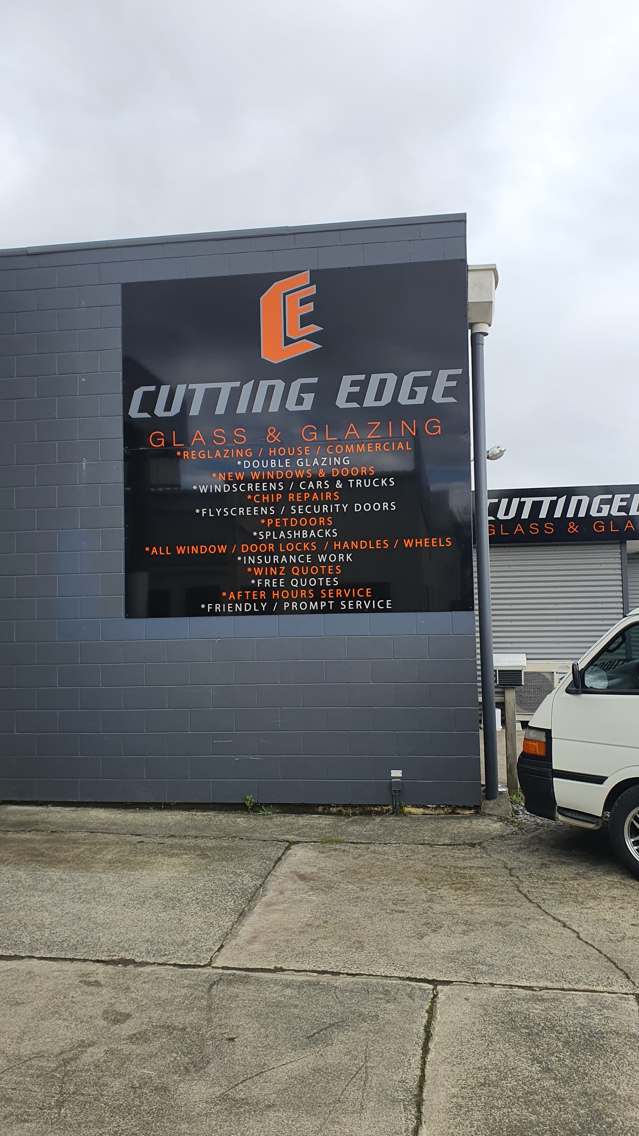 The Cutting Edge services board on the side of the building, listing reglazing, windscreens, splashbacks and more